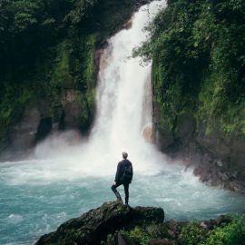 man in front of waterfall