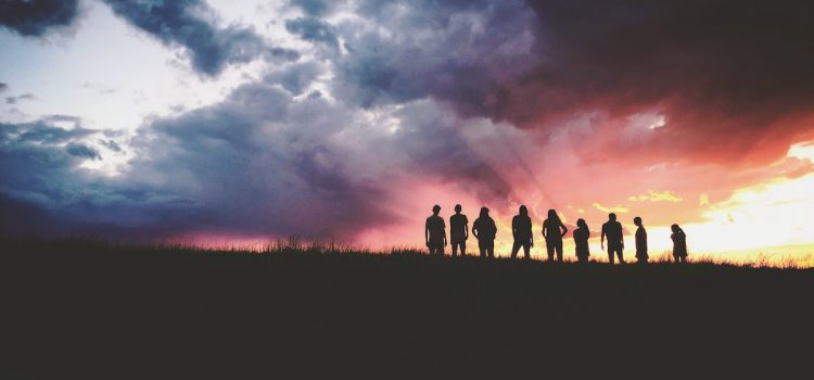 The Time Machine’s Eloi: The Utopians of the Future? A silhouette of a group of people at a sunset.