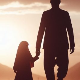 A young girl holding hands with her father in front of a sunset