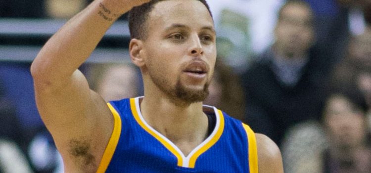 Who Is Stephen Curry? Inside the Life of the Basketball Player Stephen Curry raising his arm in a basketball game.