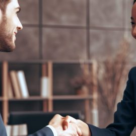 Two business people who are confident in negotiations shake hands.