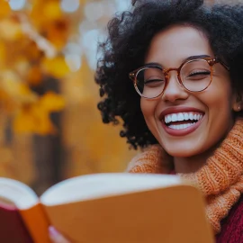 A happy woman reading a book during autumn