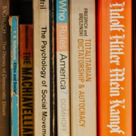 Books about Nazism, totalitarianism, socialism, and Hitler's Mein Kampf on a bookshelf illustrate the rise of Nazism