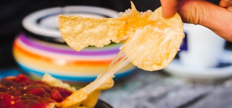 A person with a junk food addiction eating a plate of nachos