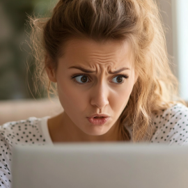 A shocked woman looking at a laptop computer screen illustrates the question, "Why do people get offended?"