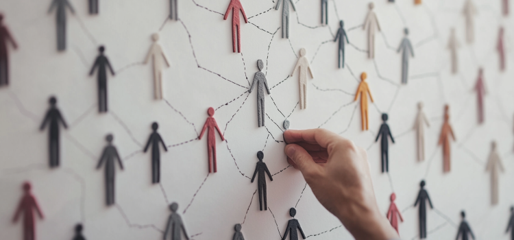 Social Unity Can Be Rebuilt: Robert Putnam’s Fourfold Vision A man's hand connecting people-shaped figures on a whiteboard illustrates social unity