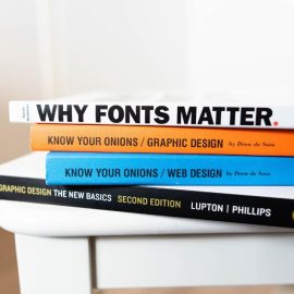 A stack of books on a table with titles that relate to visual formatting
