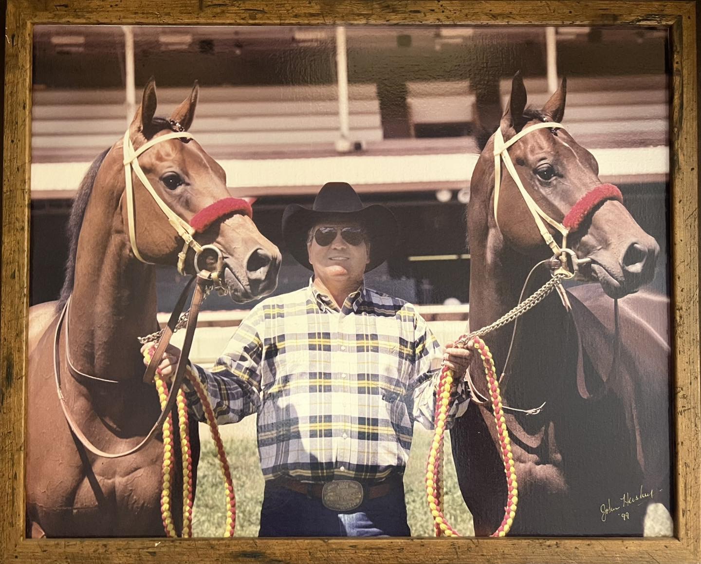 John Bassett poses with two racehorses
