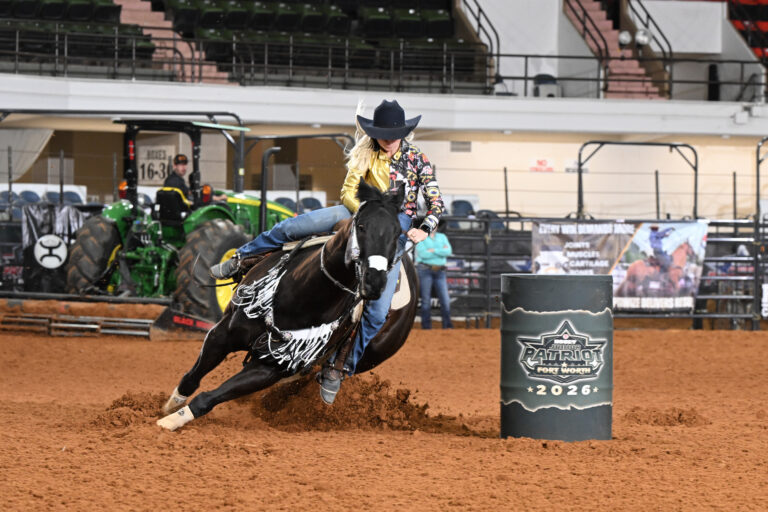 Kinley Follman turns a green barrel on her black horse