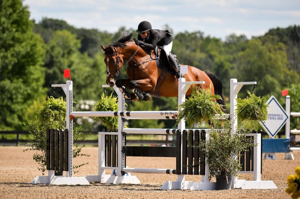 Willie Horzepa jumps over a high rail on her horse