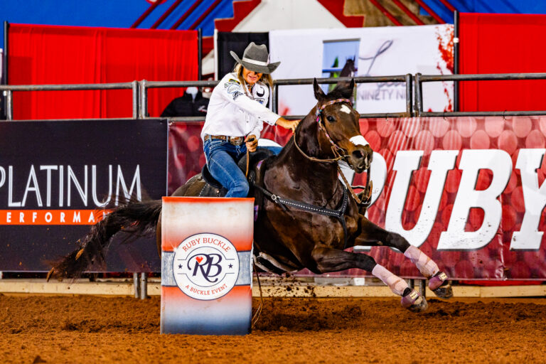 Michelle Alley turns a barrel in a white shirt on stiletto