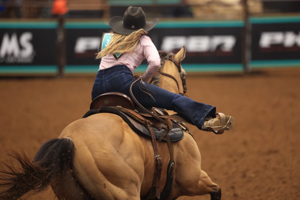 Kappie Bryant rides her horse around a barrel