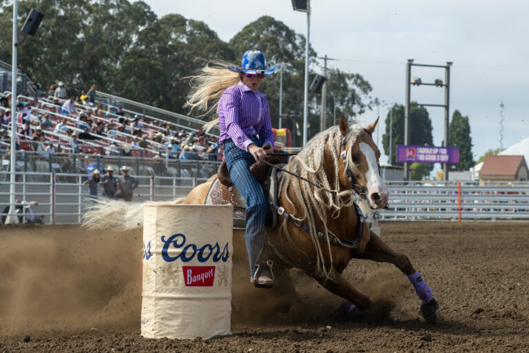 Tricia Aldridge turns a barrel on yellow horse