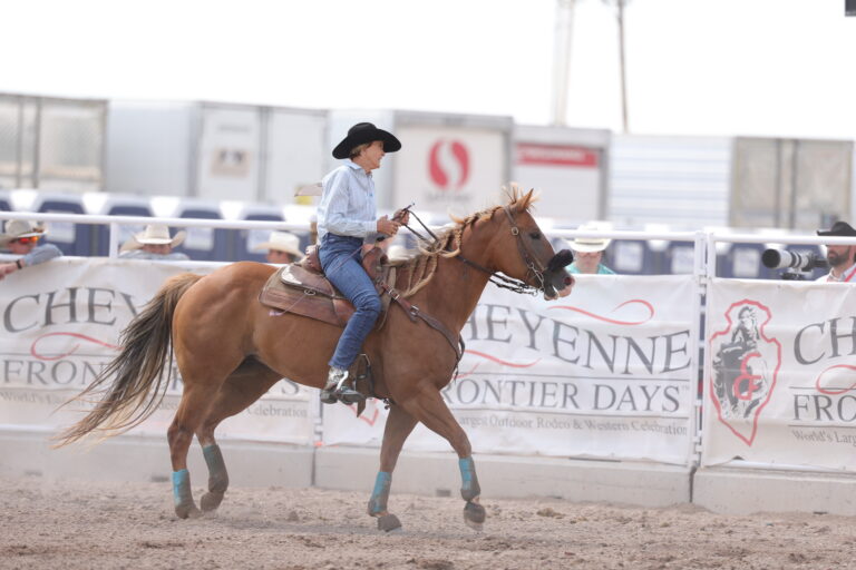 Kim Squires smile and rides her horse out of the Cheyenne Frontier Days arena