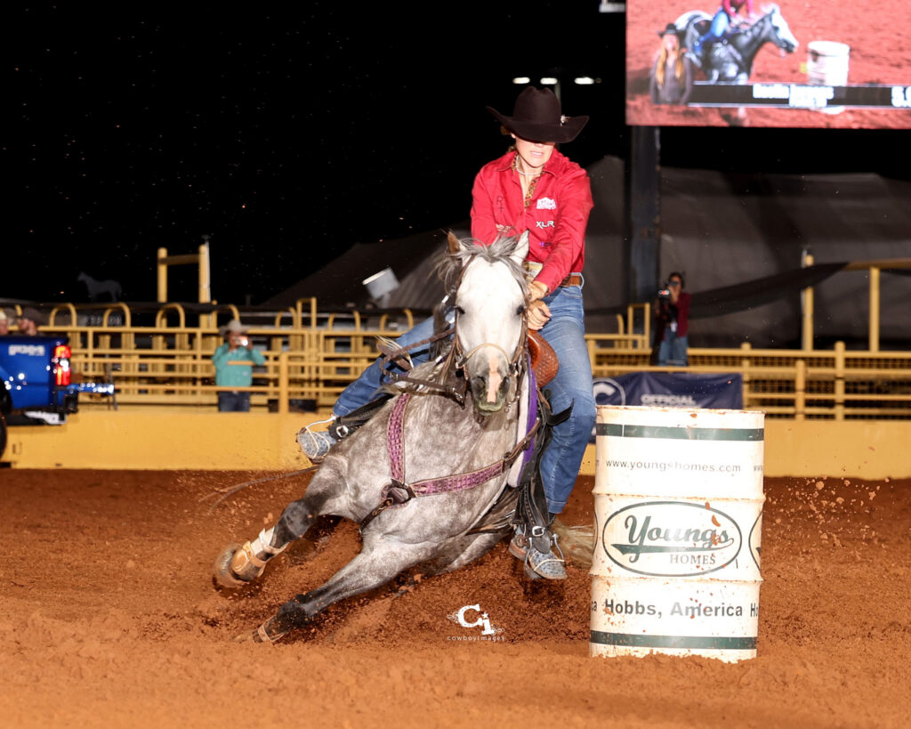 Raelin Jurgens turns a barrel on her gray horse bubba