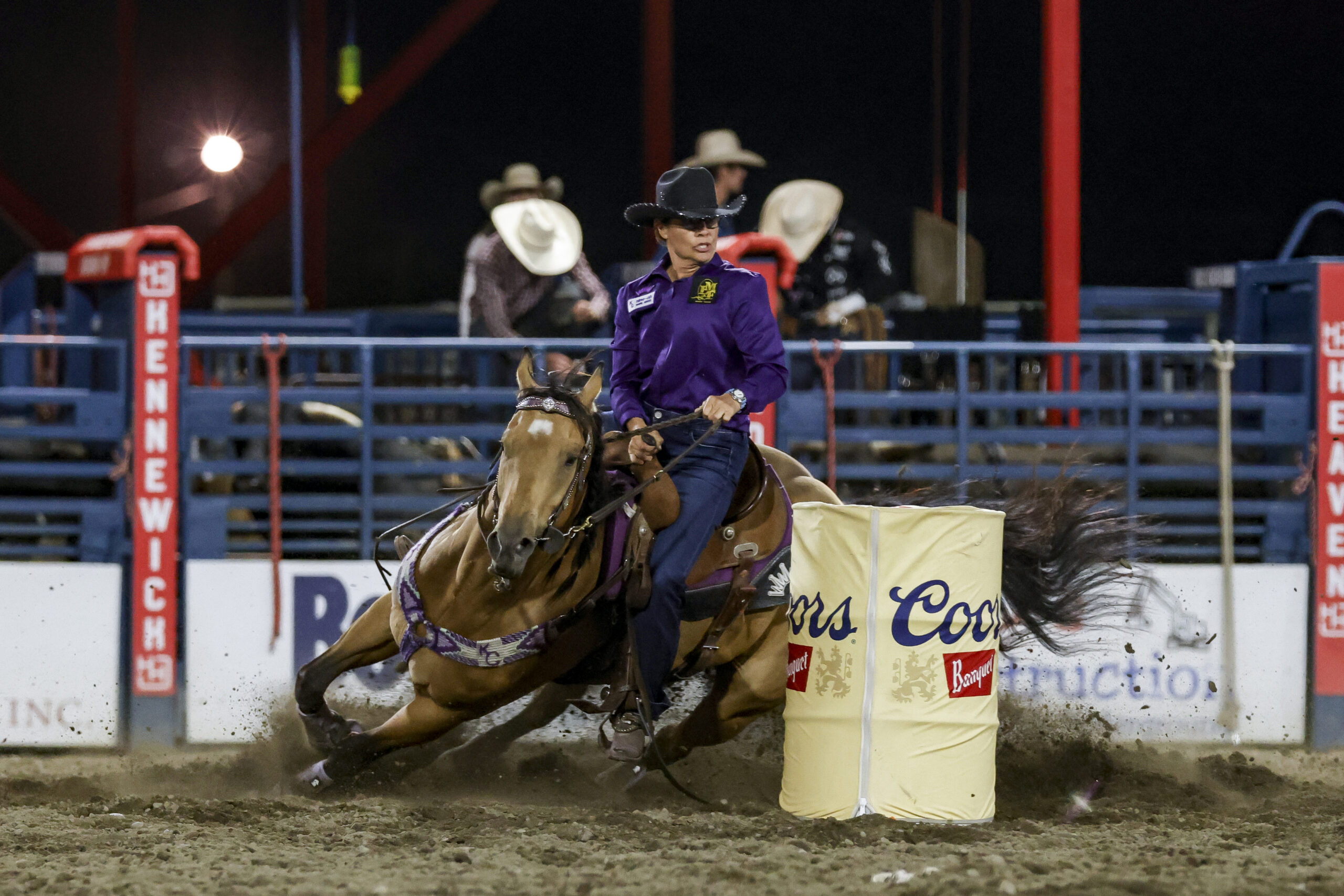 Kathy Grimes turns a barrel on a buckskin horse