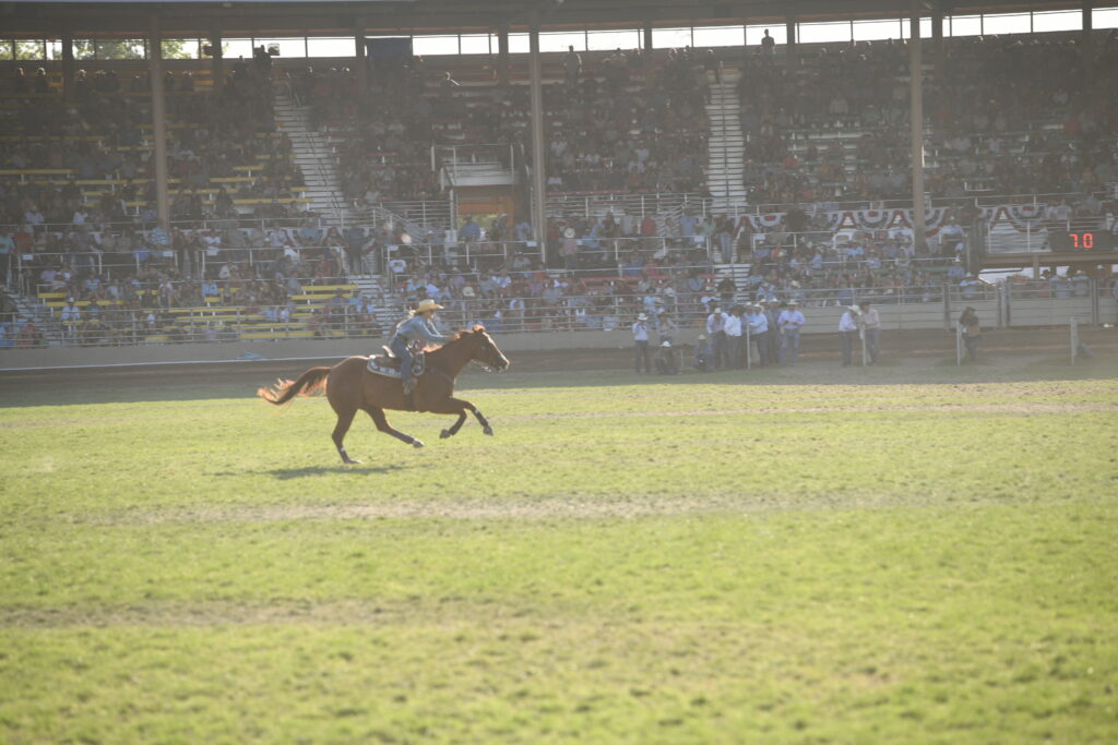 Stevi Hillman running across The Green Mile on a red horse