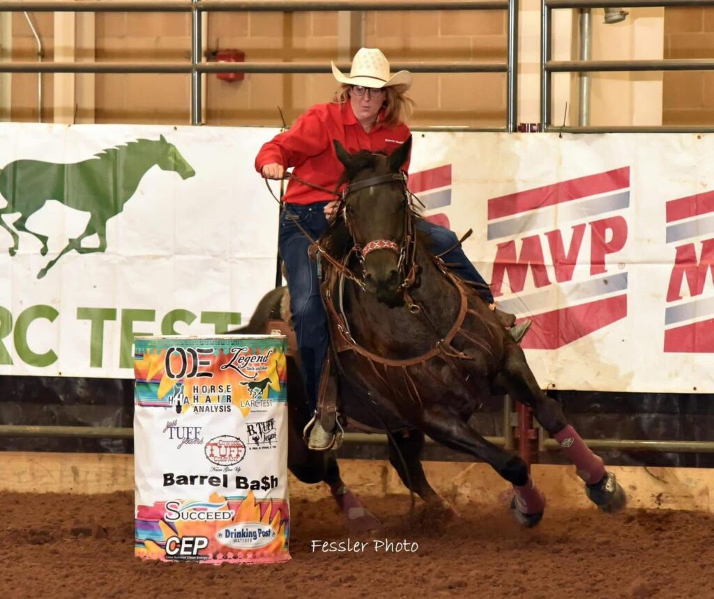 renea bolling turns a barrel on a horse in a red shirt