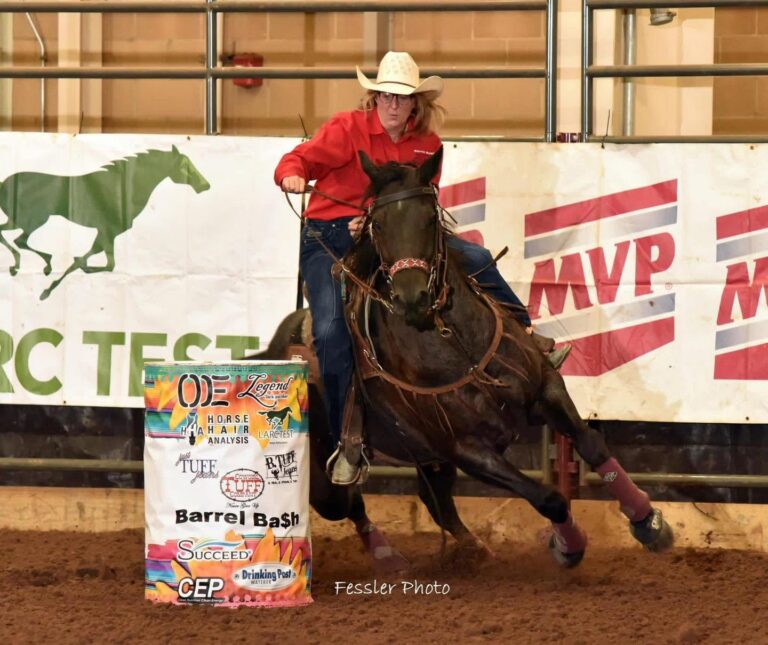 renea bolling turns a barrel on a horse in a red shirt