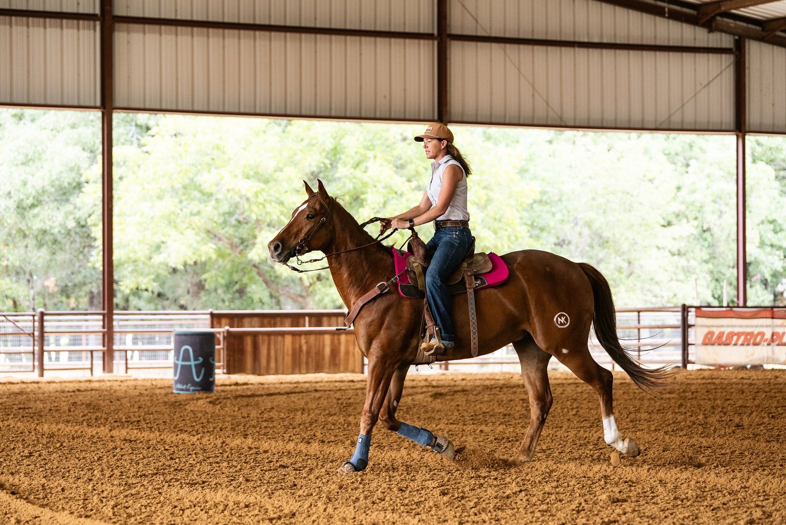 Emma Abbott loping a sorrel horse in a covered arena
