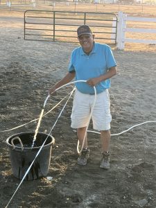 Dani Lowman's grandad Ron Alex fills up a water bucket on the road