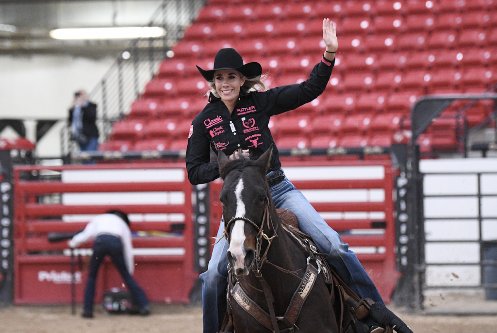 Sarah Angelone waves during her victory lap on Kelsie Domer's horse "J-LOW."