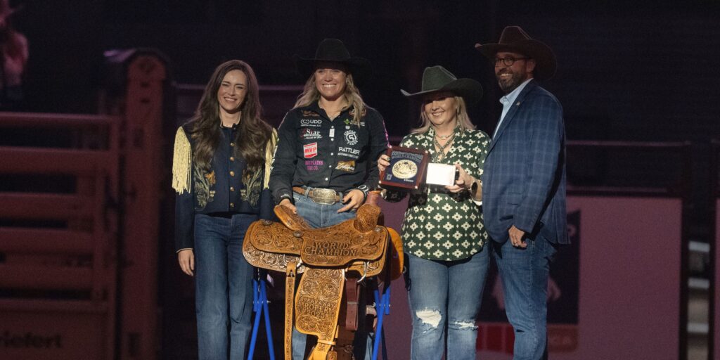 Taylor Munsell being presented her 2025 World Championship saddle and buckle.