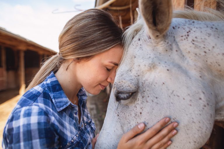 Tranquil moment between a serene girl and a beautiful white horse