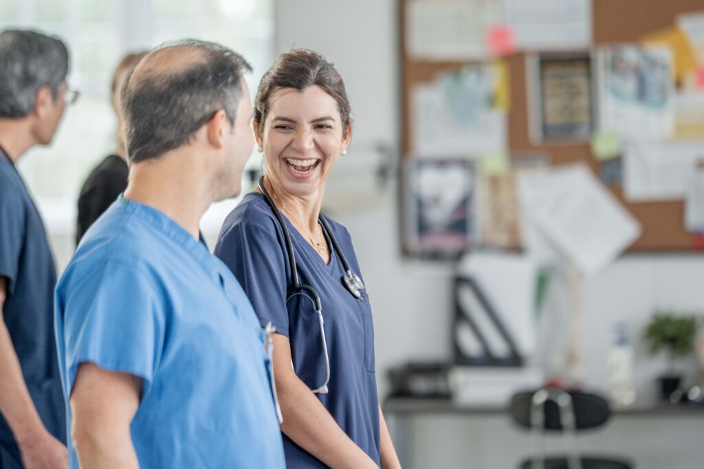 Two equine veterinarians talking in the clinic, one with a smile on her face. This highlights the benefits of being proactive in equine practice. 