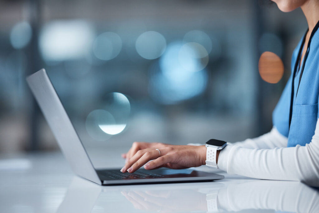 Veterinarian typing on a laptop.