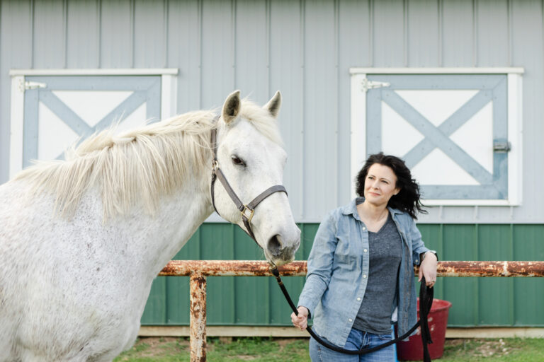 Mid adult female animal trainer gazes at the horse before they begin their session