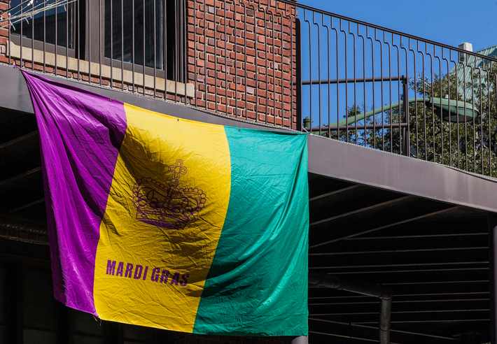 Image of Mardi Gras flag hanging from balcony in Mobile, Alabama