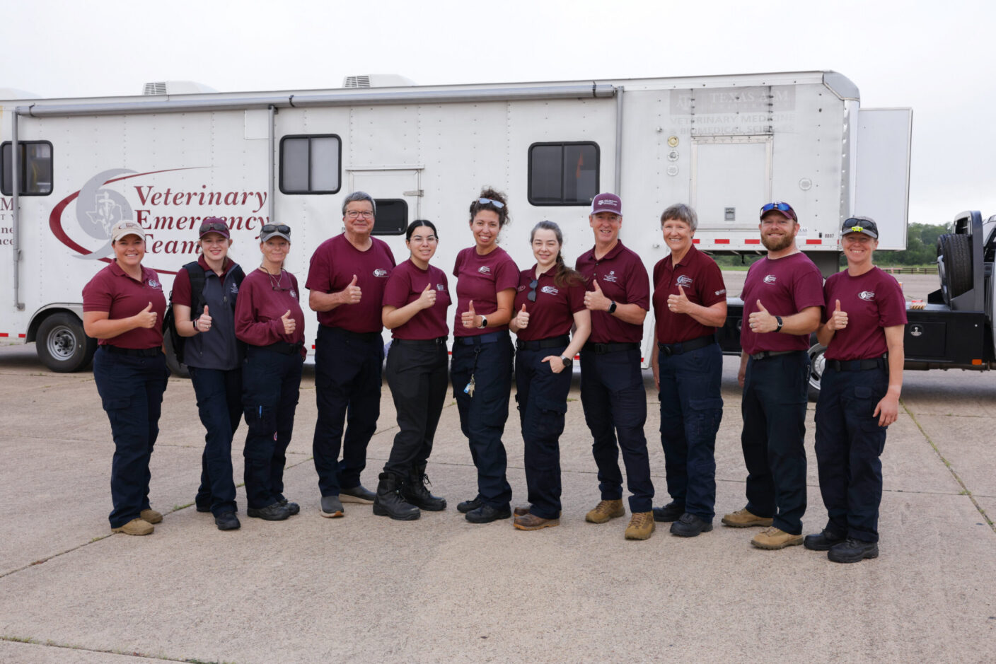 A group of people standing in front of a Veterinary Emergency Team mobilization trailer.