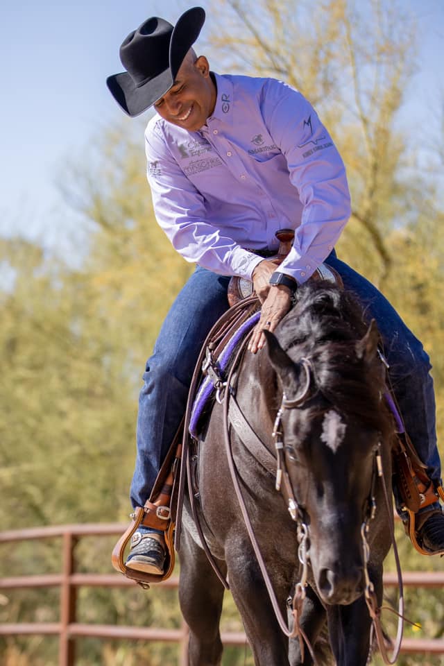 Matt Mills pets his black reining horse.