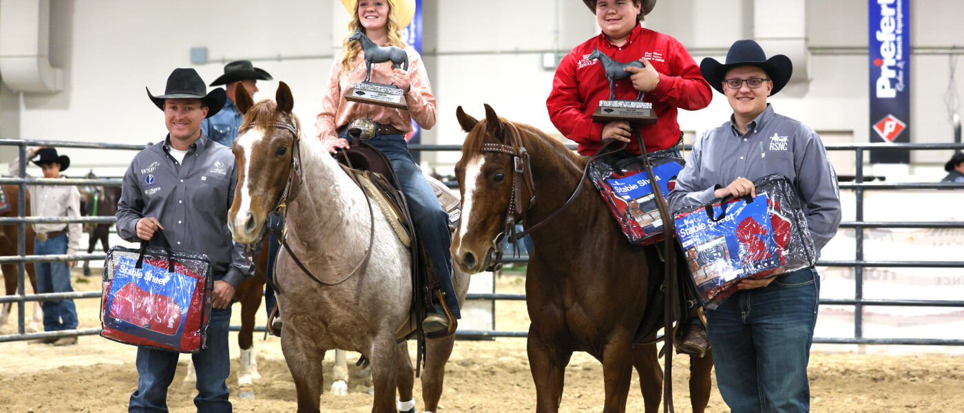 Two men give awards to two horseback riders