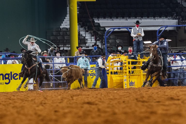 Dustin Egusquiza heading a steer for Travis Graves at the 2020 NFR.
