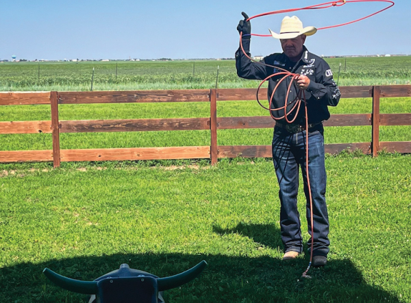 Kory Koontz swinging rope toward roping dummy