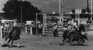 Black and white photo of Charmayne James team roping with Pam Minick.