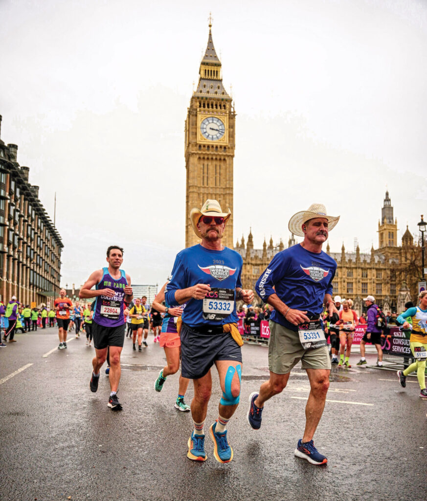 two men in cowboy hats running in a crowd of marathon runners at the 2023 London Marathon