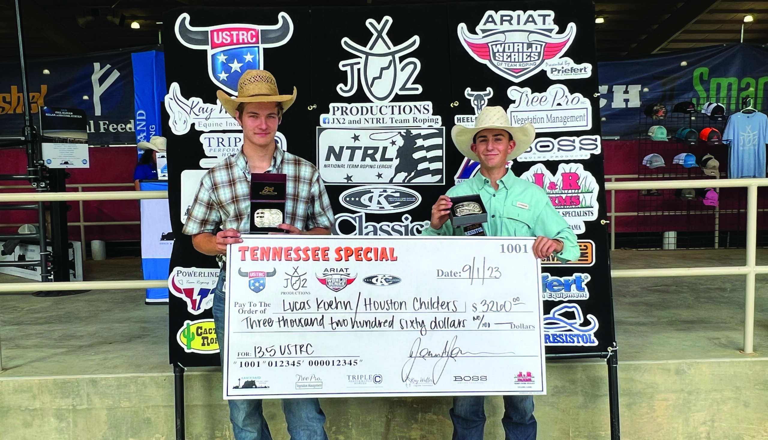 Lucas Koehn and Houston Childers stand next to each other holding a large check for $3,260.