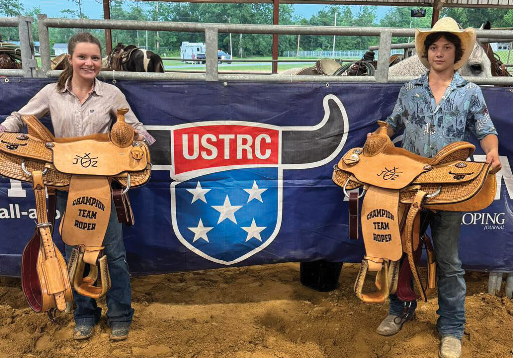 Lexi Andrews and Lawson Woodward display trophy saddles won at the #7.5 USTRC at the Florida Panhandle Championships.