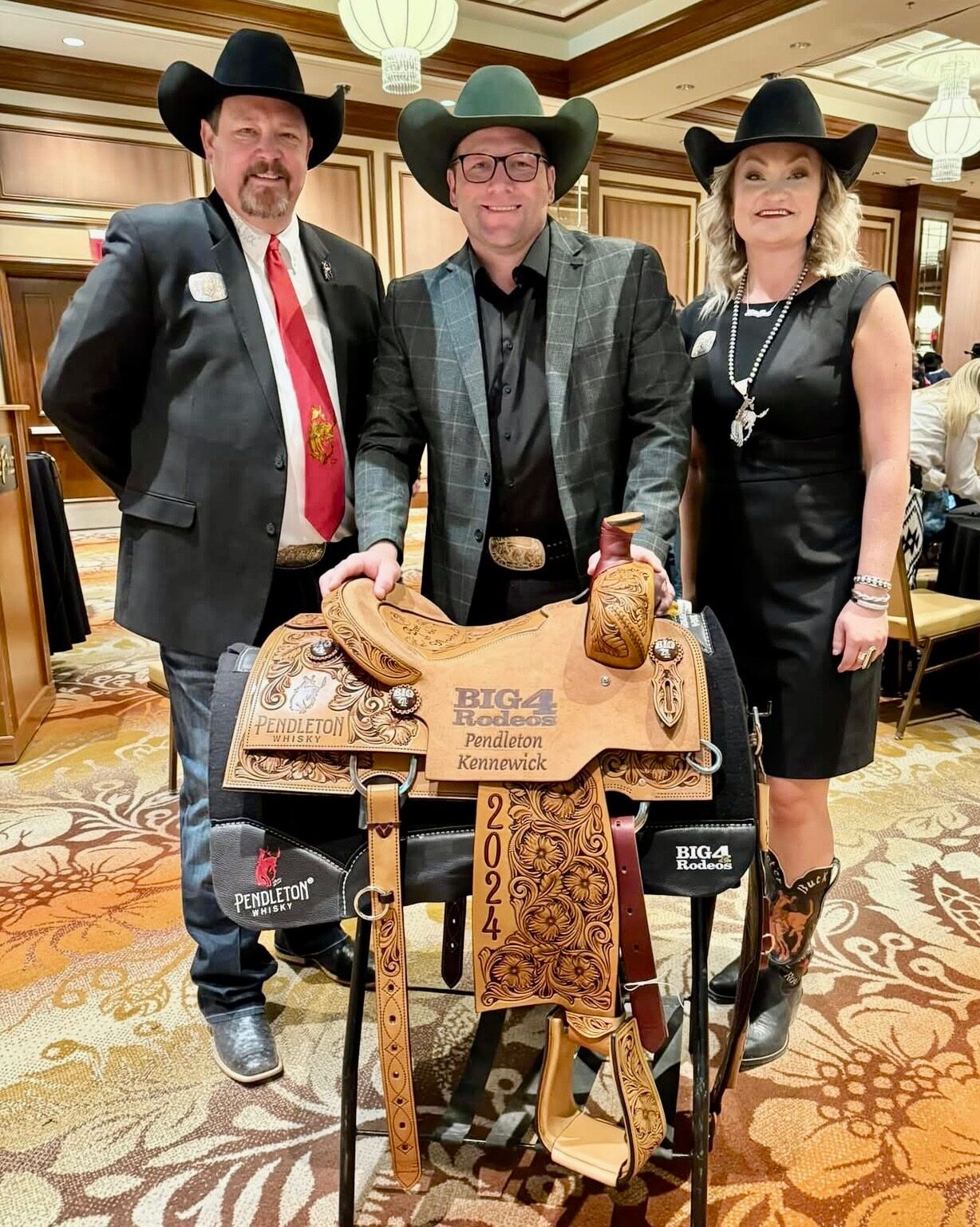 Pendleton’s Pat Reay, left, and Tiah DeGrofft, right, presented Coleman Proctor his Big 4 saddle here in Las Vegas.