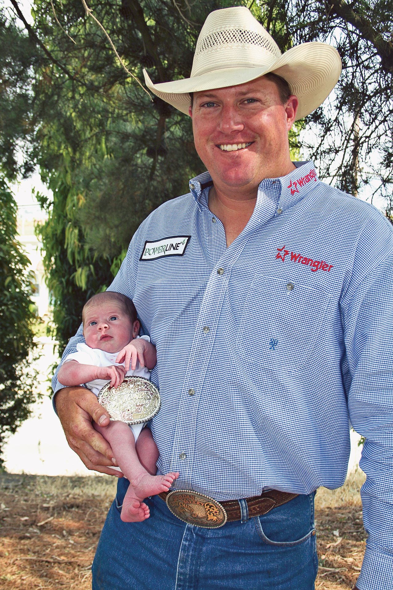 Kyle Lockett holding his newborn daughter Shayla Jeanne and his Salinas all-around buckle in 2006