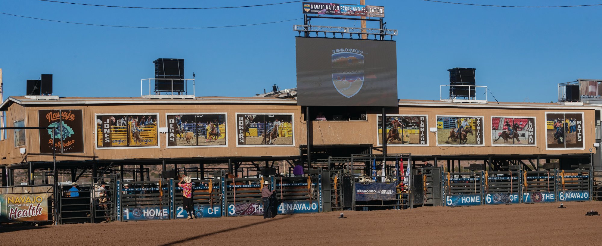 Large banner photos of Navajo Nation NFR qualifiers decorate the bucking chutes at the Home of the Navajo PRCA Rodeo