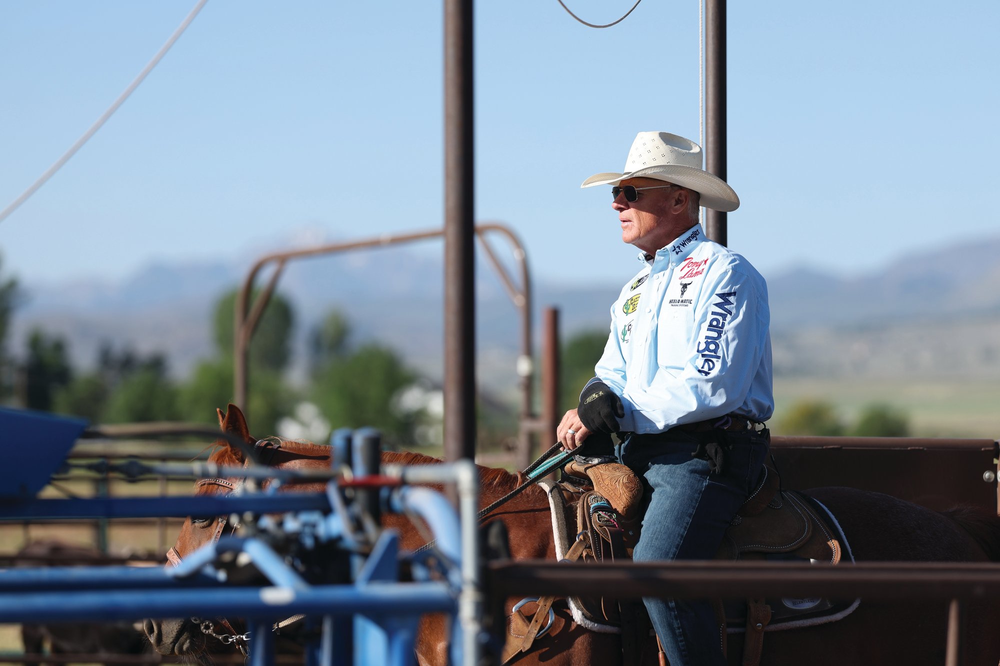 Clay O’Brien Cooper on horseback behind the roping chutes