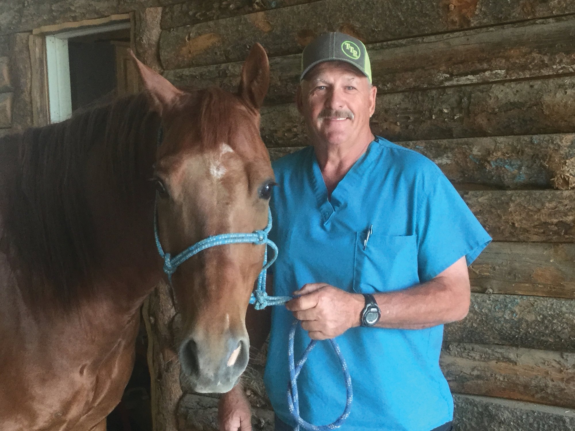Joe Stricklin, DVM, standing with a sorrel horse