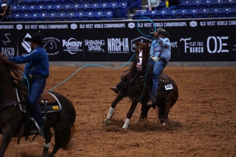 Hunter Koch swings his rope on Rebel X, a sorrel stallion with a blaze, in front of Old West World Championships banners in Amarillo.