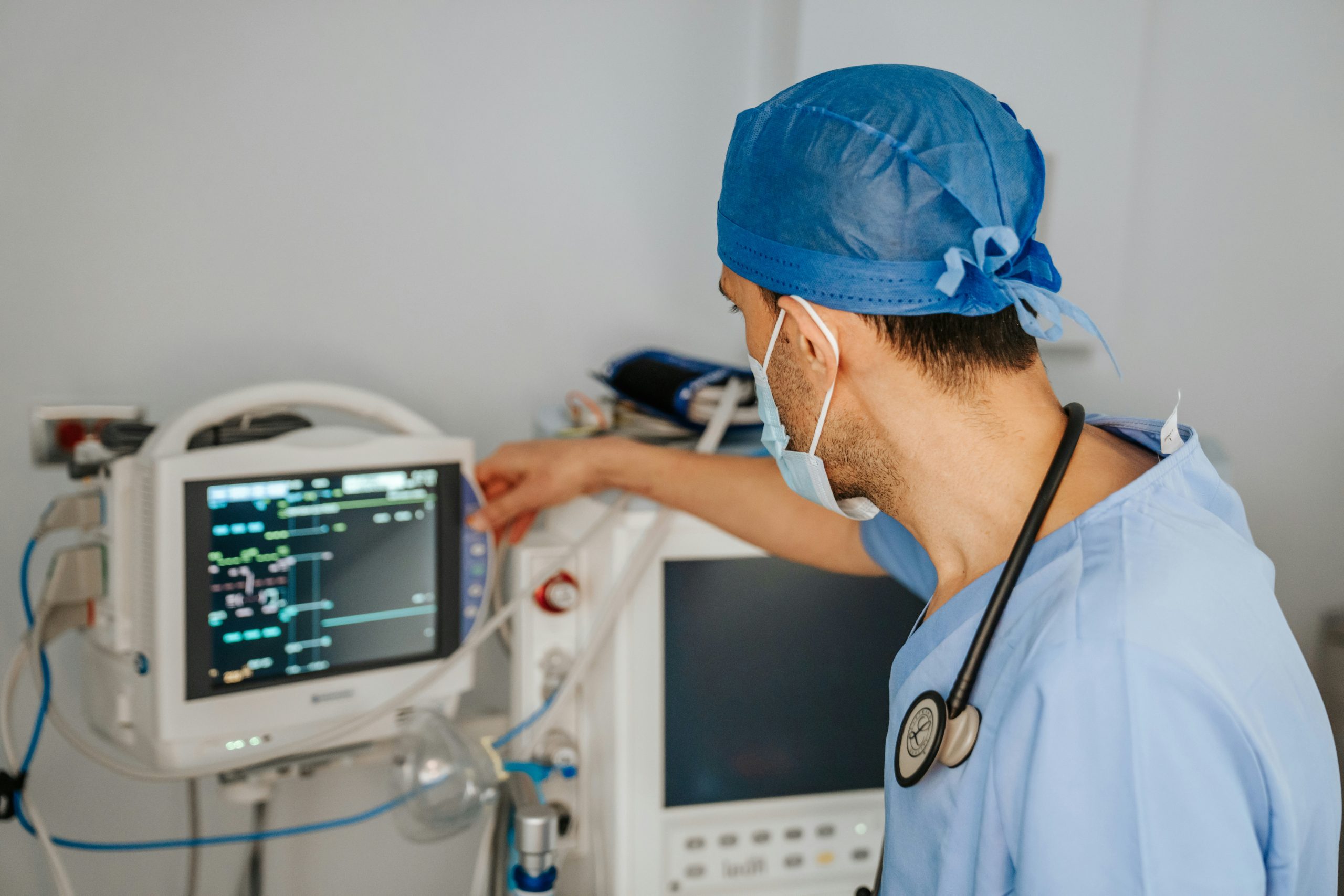 In this photo, a dedicated doctor carefully handles a vital signs monitor, using advanced technology to monitor and track crucial health indicators. With unwavering focus, the doctor ensures accurate data for effective medical care.