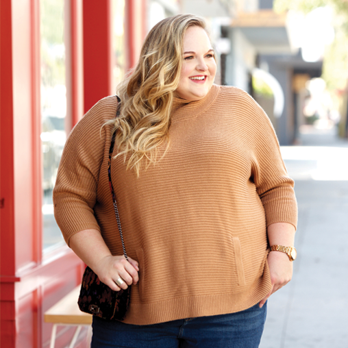 reah norman wearing a plus size sweater and denim