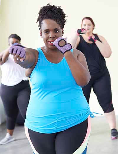 CeCe boxing, with two women behind her.